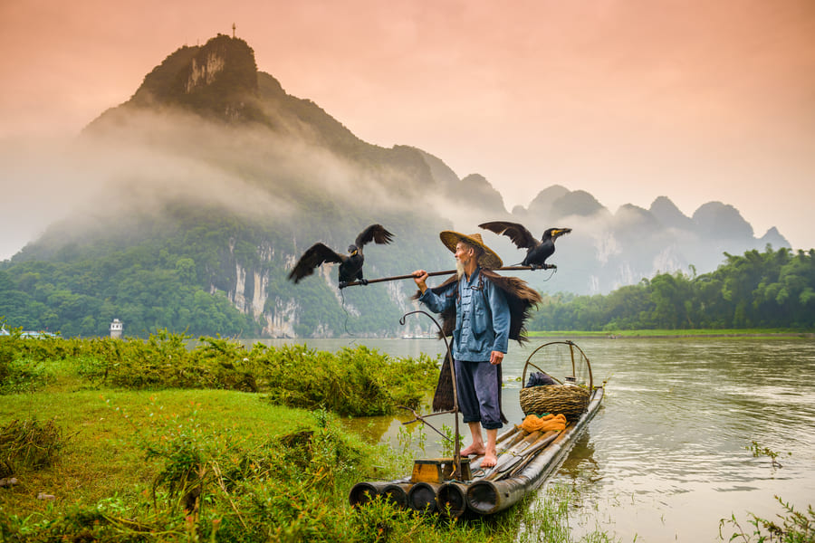 Paisaje con un hombre pescador en el rio Cormoran, en Yangshuo, China.